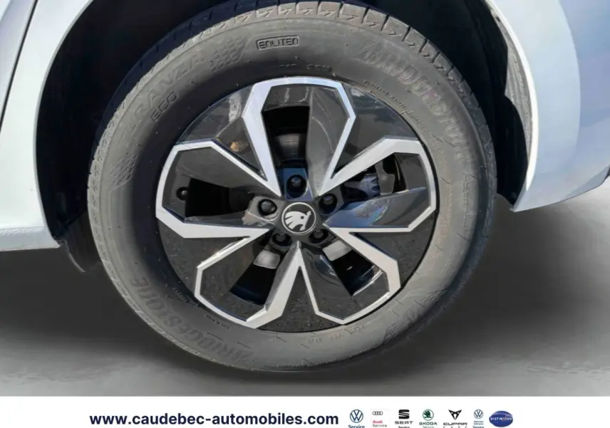 Gros plan sur la roue avant gauche blanche d'un Skoda Kamiq 2025 avec jante alliage noir et argentée.