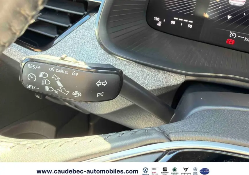 Gros plan sur la commande de régulateur de vitesse et le tableau de bord numérique du Skoda Kamiq blanc 2025.