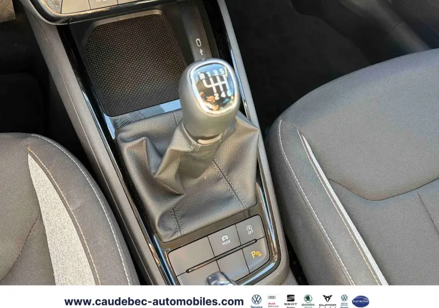 Gros plan sur la console centrale du Skoda Kamiq 2025, mettant en valeur le levier de vitesses manuel et les sièges gris.