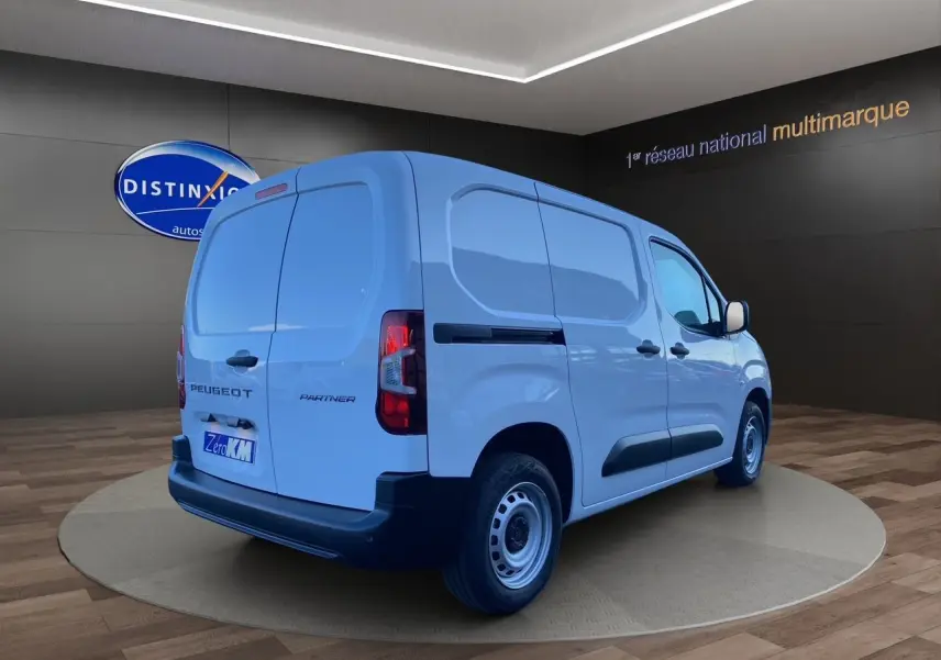 Vue 3/4 arrière droite d'un utilitaire Peugeot Partner blanc avec portes arrière battantes et jantes acier simples.