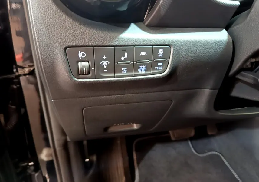 Gros plan sur les commandes de réglage et assistances côté conducteur du tableau de bord noir du Hyundai Kona 2020.