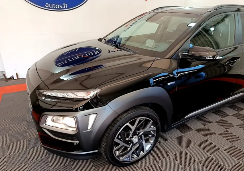 Vue 3/4 avant droite d'un Hyundai Kona noir avec feux allumés et jantes alliage modernes.