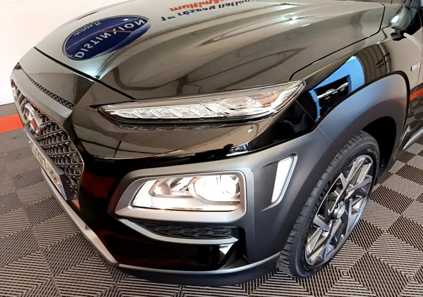 Vue 3/4 avant droit d'un Hyundai Kona noir mettant en valeur ses phares LED et sa calandre distinctive.