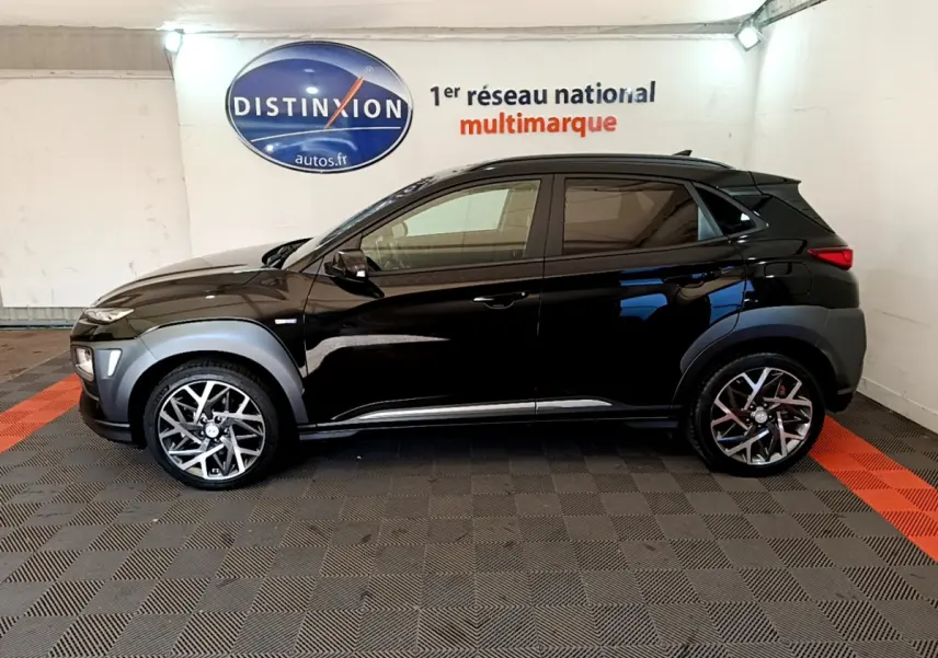 Profil côté gauche du Hyundai Kona noir 2020 avec jantes alliage et protections grises sur les passages de roues.