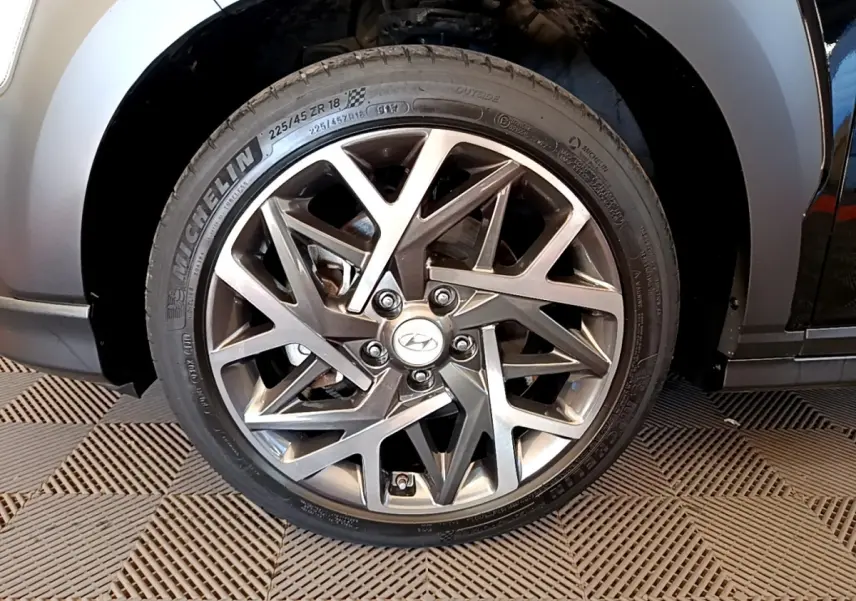 Gros plan sur la roue avant droite du Hyundai Kona noir 2020, mettant en valeur la jante alliage au design géométrique.