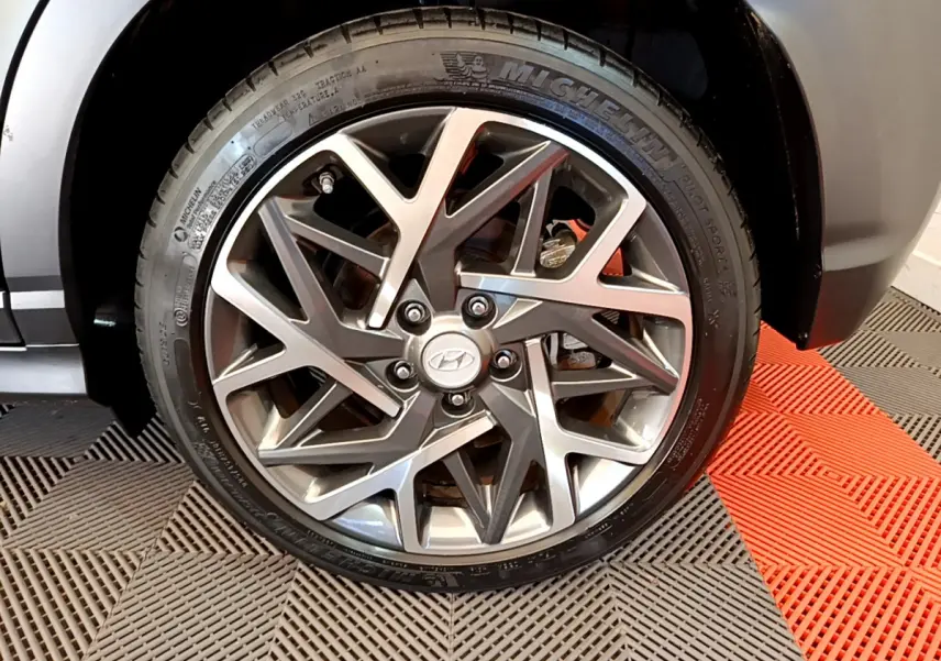 Gros plan sur la roue avant gauche noire du Hyundai Kona 1.6 GDi Hybrid avec jante alliage au design géométrique.