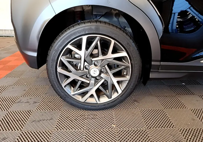 Gros plan sur la roue avant gauche du Hyundai Kona noir 2020, mettant en valeur la jante alliage au design géométrique.