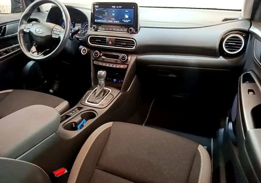 Intérieur avant du Hyundai Kona 1.6 GDi Hybrid 2020, tableau de bord noir avec écran tactile et volant multifonctions.