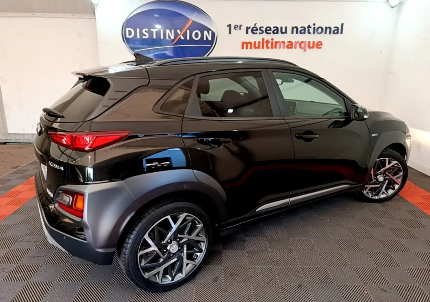 Vue 3/4 arrière droite d'un Hyundai Kona noir 2020 avec jantes alliage et protections grises sur les passages de roues.