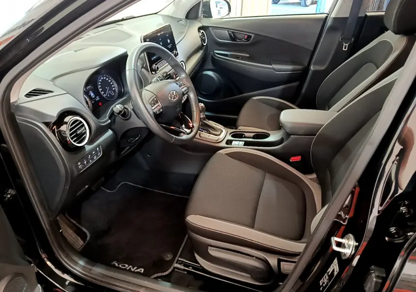 Intérieur côté conducteur du Hyundai Kona noir 2020, avec tableau de bord moderne et sièges tissu gris.