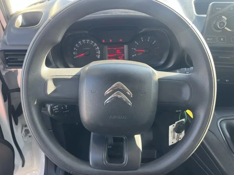 Vue rapprochée du volant noir avec logo Citroën et tableau de bord numérique du Berlingo Fourgon blanc Banquise 2020.