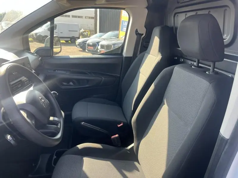 Intérieur du Citroën Berlingo Fourgon 2020, vue côté conducteur montrant sièges tissu gris et tableau de bord noir.