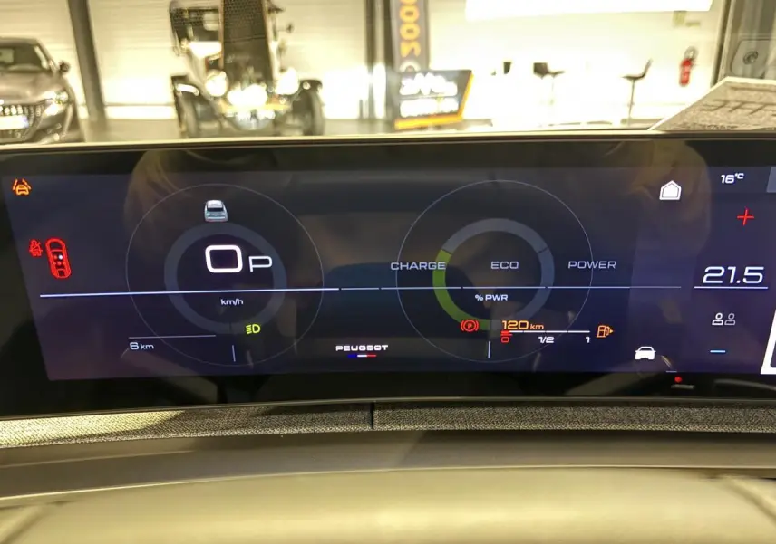 Vue rapprochée du tableau de bord numérique du Peugeot 3008 gris Artense, affichant les indicateurs de charge et vitesse.