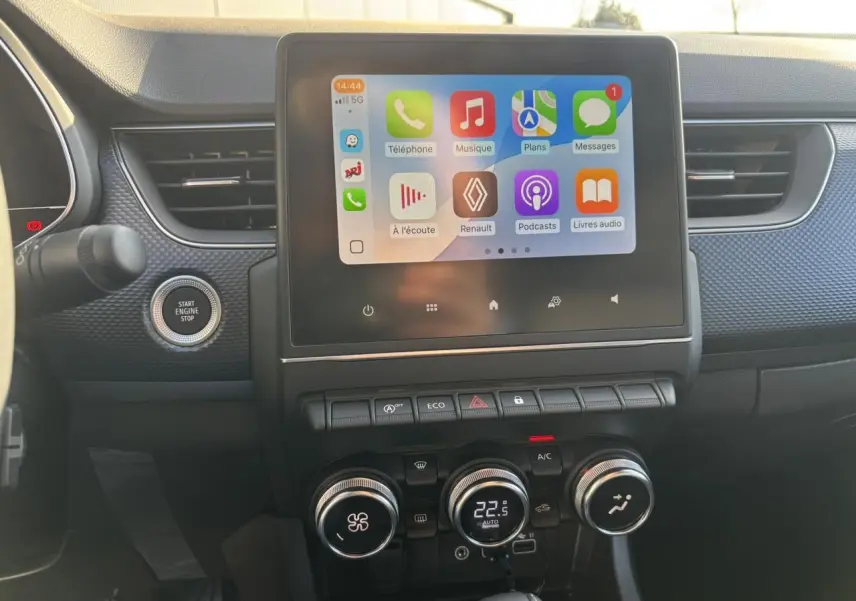 Vue rapprochée du tableau de bord noir du Renault Arkana 2025 avec écran tactile affichant Apple CarPlay.