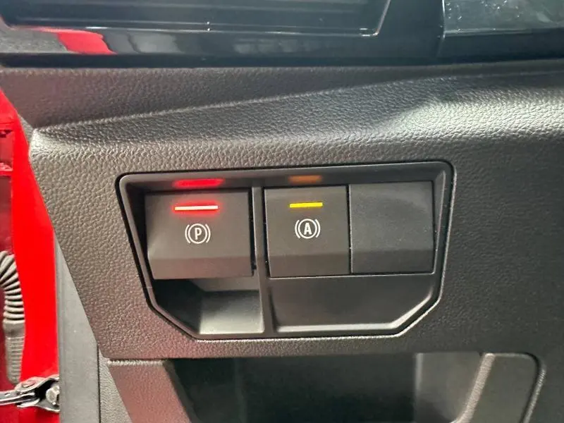 Gros plan sur les boutons de commande électroniques du frein à main et du système start-stop du Renault Austral Rouge Flamme 2025.