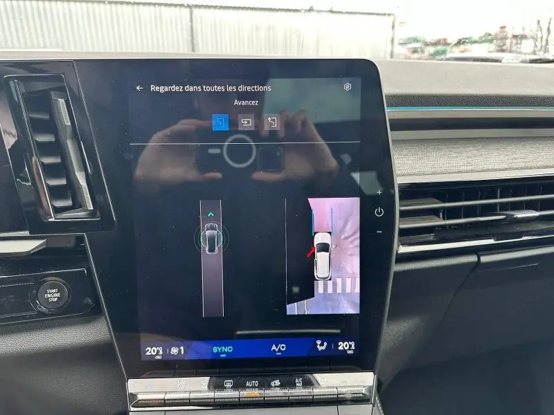 Vue intérieure du tableau de bord du Renault Austral 2025, écran tactile affichant la caméra 360 et commandes climatisation.