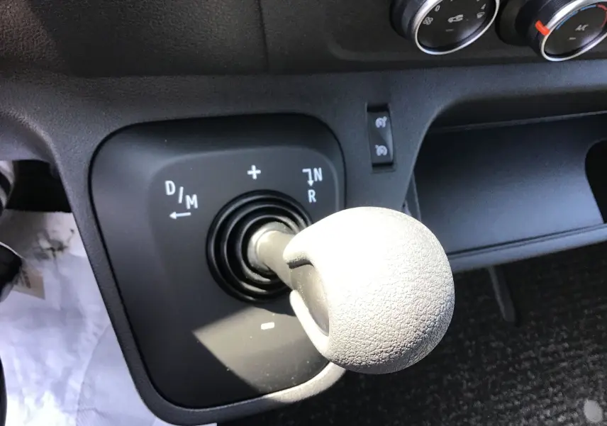 Le levier de vitesses automatique gris du Renault Master 2024 vu de dessus avec les commandes de climatisation en arrière-plan.