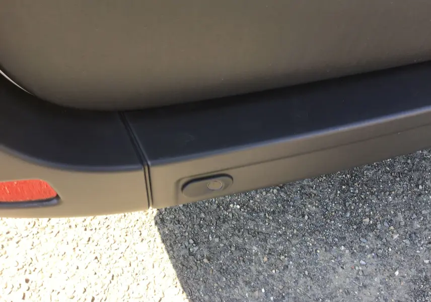 Gros plan sur le pare-chocs arrière gris étoile du Renault Master 2024 avec capteur de recul intégré.