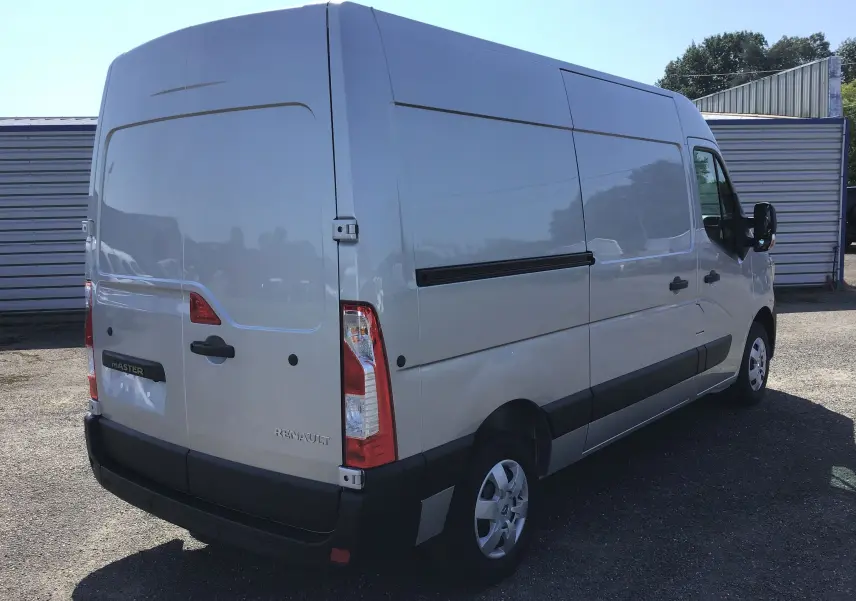 Vue 3/4 arrière droite d'un Renault Master gris étoile 2024 avec enjoliveurs maxi et pare-chocs noirs robustes.