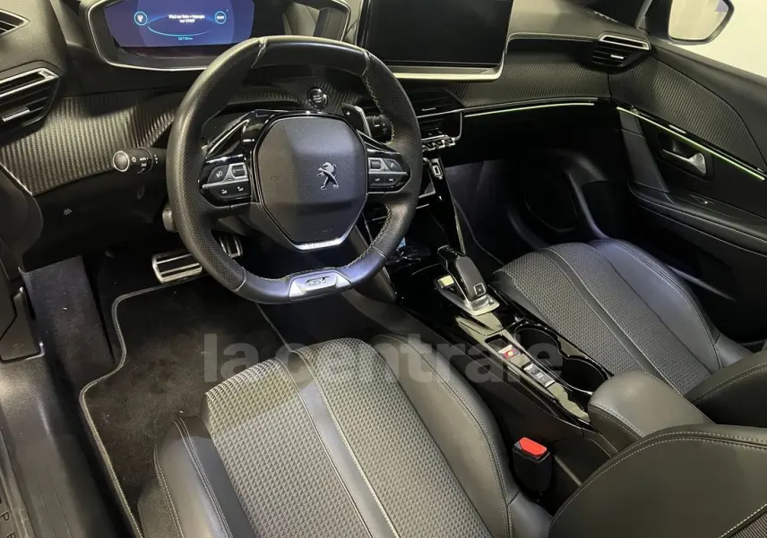 Intérieur de la Peugeot 208 GT Line 2020 vu côté conducteur, avec volant compact et éclairage d'ambiance vert.
