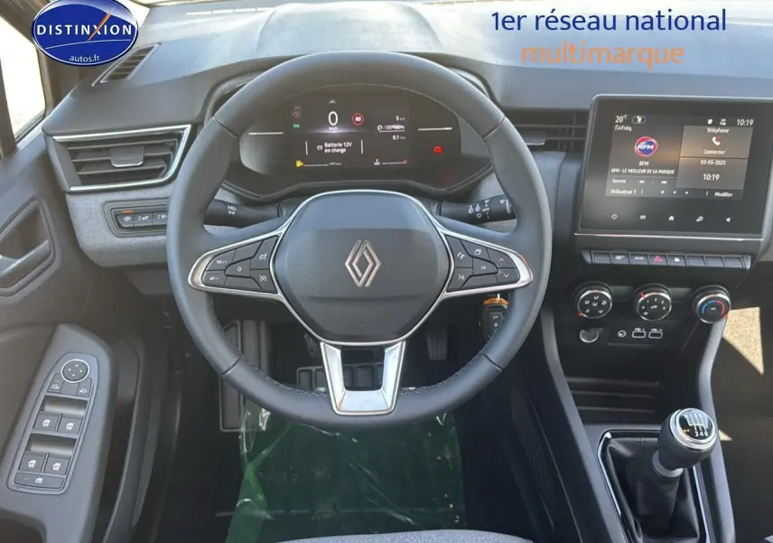Intérieur de la Renault Clio 2025, vue de face sur le volant, tableau de bord numérique et levier de vitesses manuel.