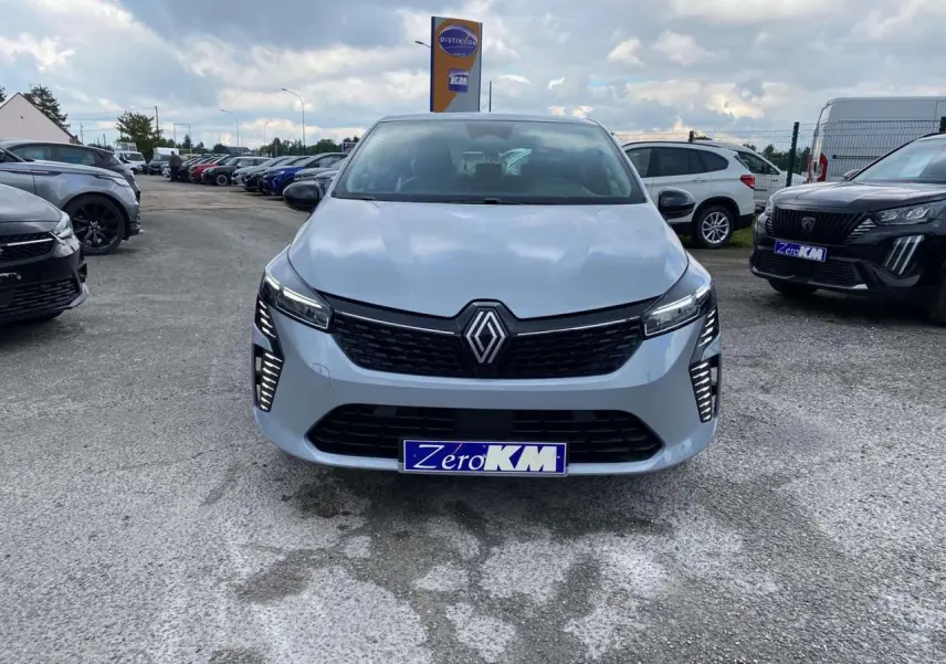 Vue frontale d'une Renault Clio 2025 gris rafale avec éclairage LED et plaque d'immatriculation Zero KM visible.