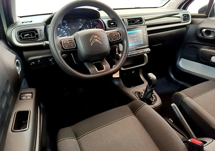 Intérieur de la Citroën C3 PureTech 82 2019, vue côté conducteur, tableau de bord noir avec écran tactile 7 pouces.