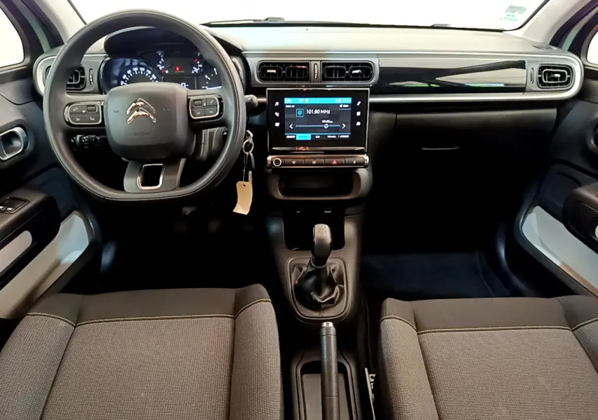 Vue intérieure avant de la Citroën C3 PureTech 82 vert, tableau de bord avec écran tactile et volant multifonctions.