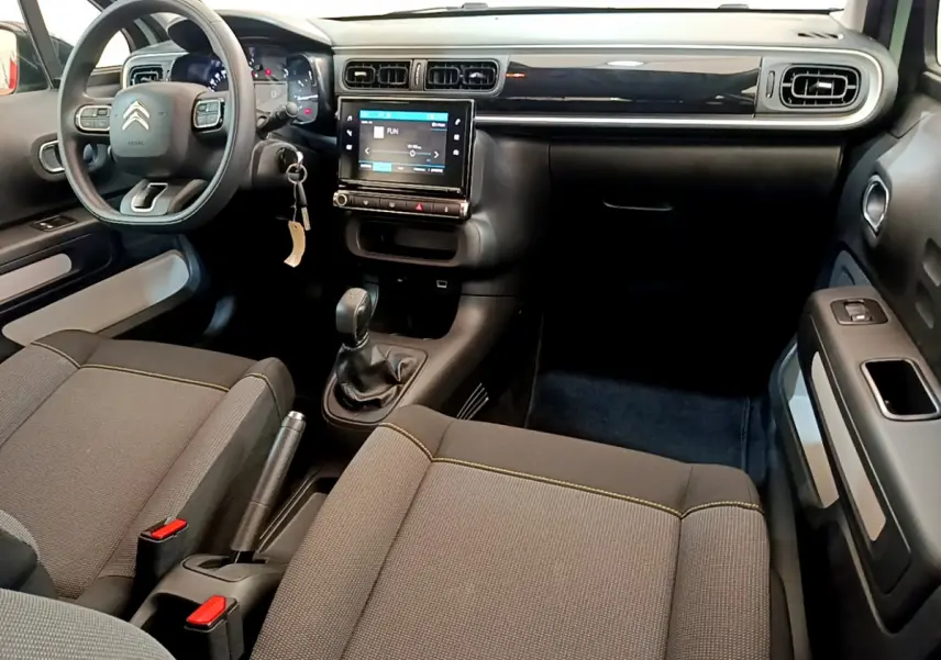 Intérieur avant du Citroën C3 PureTech 82 2019, vue du côté conducteur avec tableau de bord noir et écran tactile central.