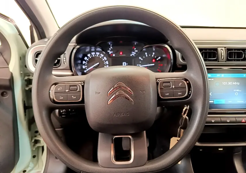 Vue centrée sur le volant noir de la Citroën C3 PureTech 82, avec tableau de bord et écran tactile visibles.