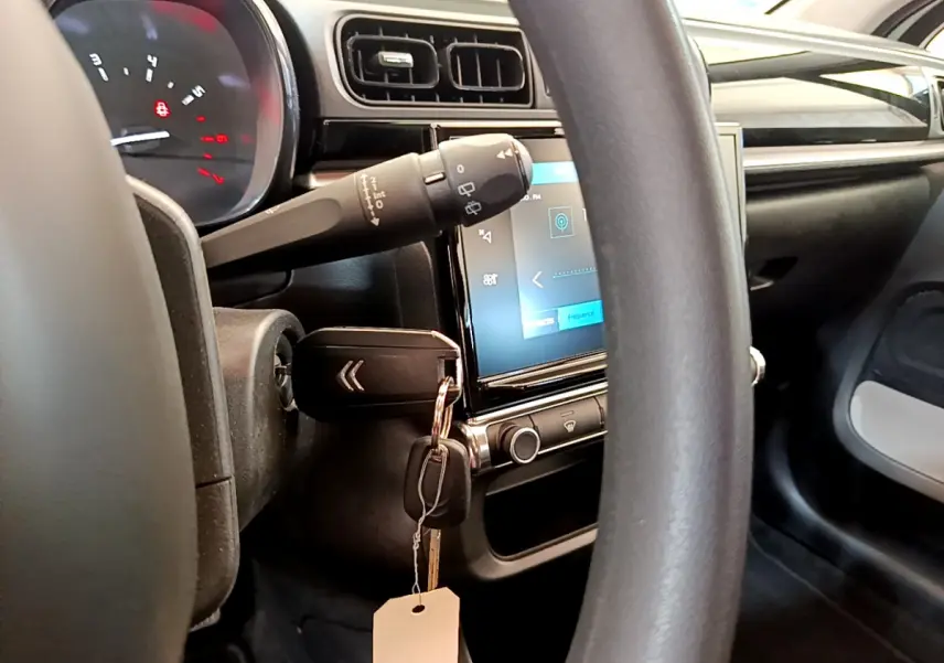 Intérieur de la Citroën C3 PureTech 82 vu côté conducteur, volant noir et écran tactile central allumé.