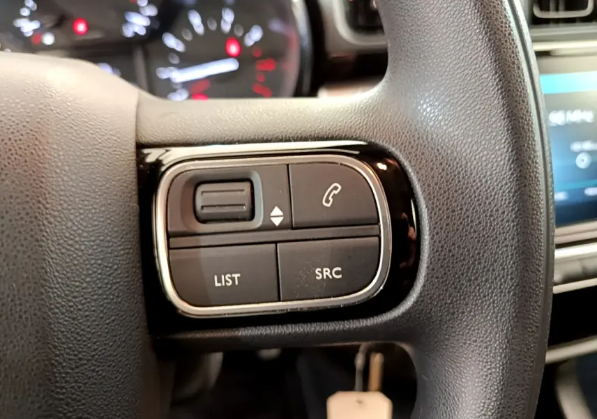 Gros plan sur les commandes gauche du volant noir du Citroën C3 PureTech 82 S&S BVM Graphic 2019.