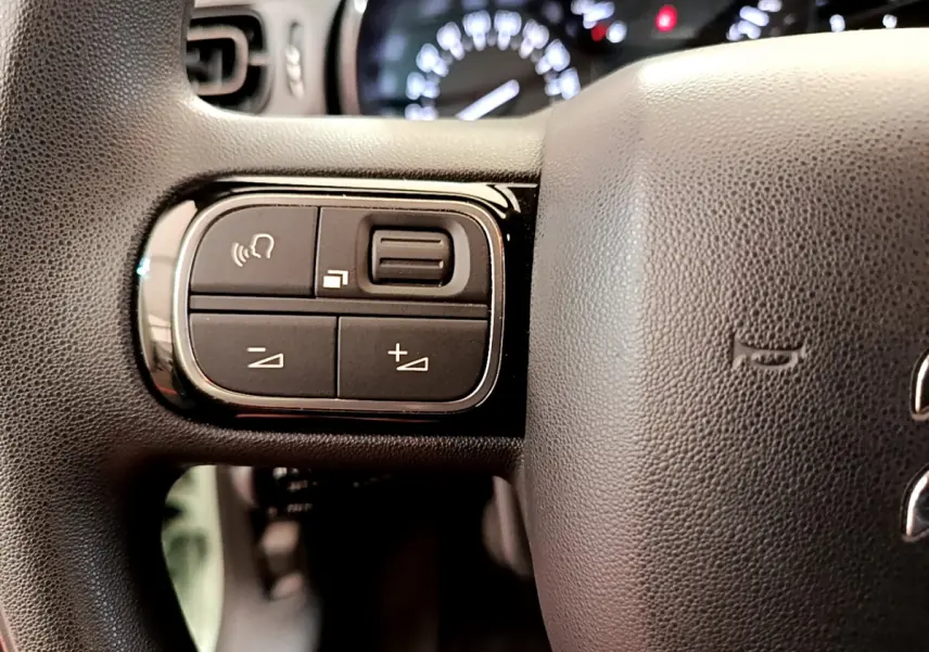 Gros plan sur les commandes gauche du volant noir de la Citroën C3 PureTech 82 S&S BVM Graphic 2019.