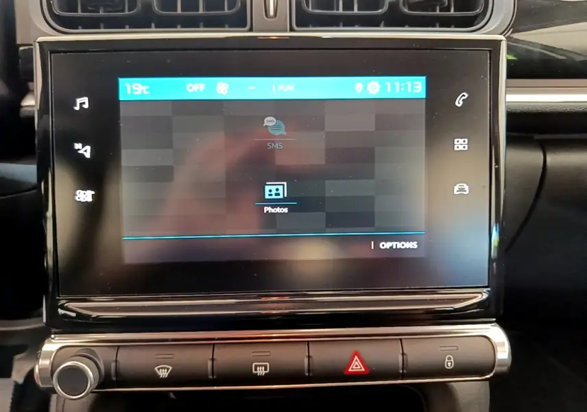 Écran tactile central affichant menu multimédia dans l'habitacle noir d'une Citroën C3 PureTech 2019.