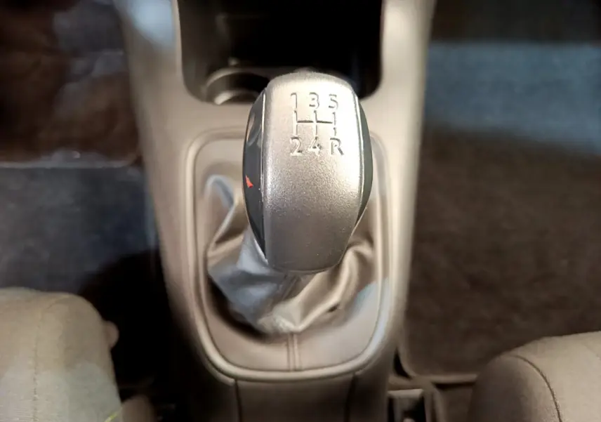 Le levier de vitesses manuel gris de la Citroën C3 PureTech 82 vu de dessus, entouré de sièges tissu gris.