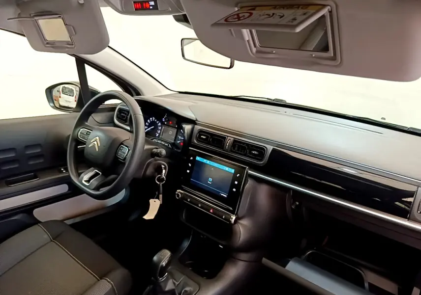 Intérieur de la Citroën C3 PureTech 82, vue côté conducteur montrant le tableau de bord noir et l'écran tactile central.