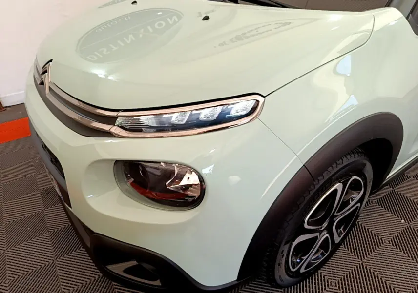 Vue 3/4 avant droit d'une Citroën C3 PureTech 82 vert clair avec phares LED et jantes noires stylisées.