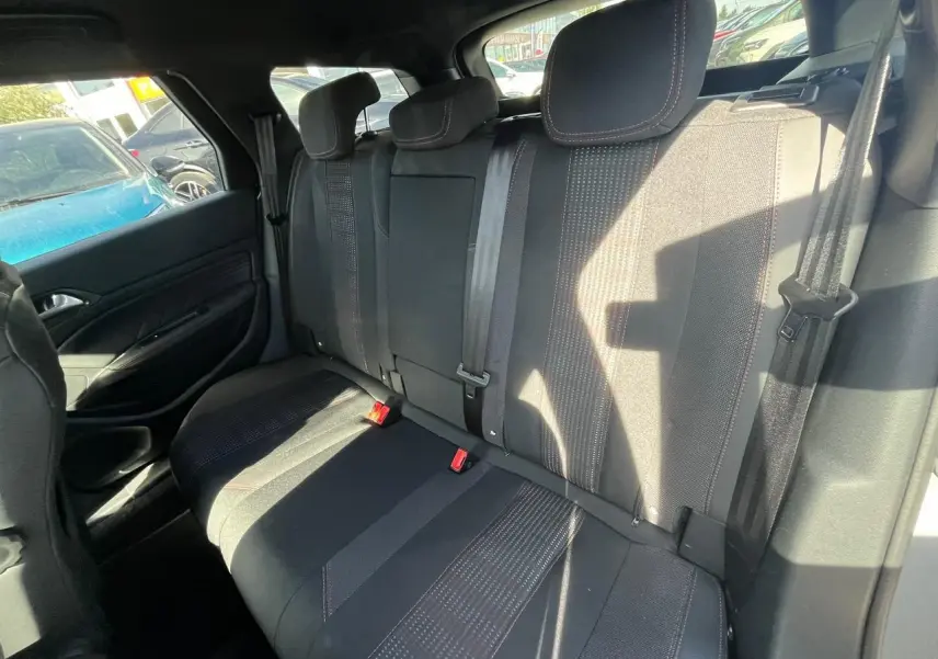Vue intérieure côté droit des sièges arrière noirs avec surpiqûres rouges de la Peugeot 308 SW gris clair 2019.