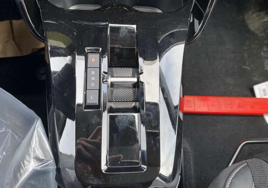 Gros plan sur la console centrale noire brillante avec sélecteur de boîte automatique du Citroën C3 Aircross hybride 2025.