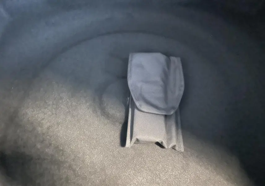 Gros plan sur le rangement intégré dans le coffre du Peugeot 3008 blanc Okenite, version hybride GT 2025.