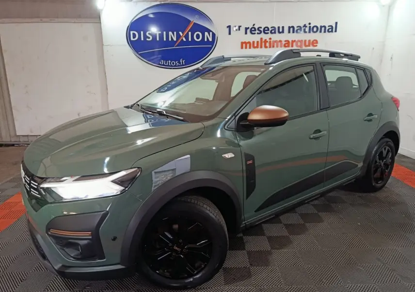 Vue 3/4 avant droite d'une Dacia Sandero Extreme+ TCe 110 2024 vert avec rétroviseurs cuivrés et jantes noires.
