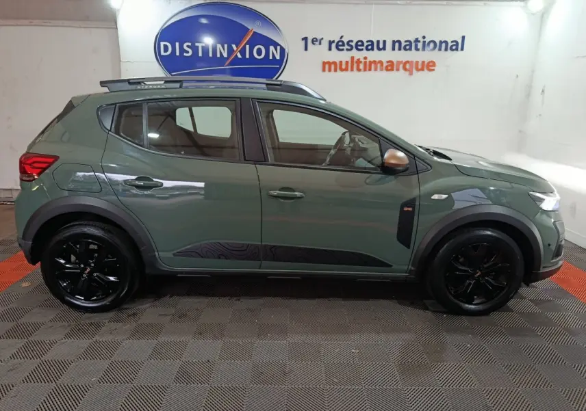 Vue de profil côté gauche d'une Dacia Sandero Extreme+ TCe 110 2024 verte avec jantes noires et rails de toit assortis.
