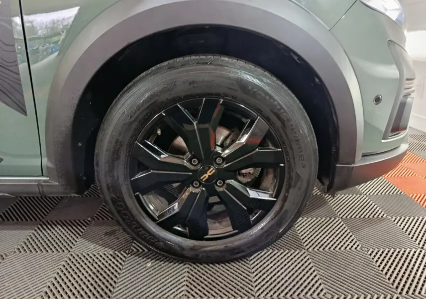 Gros plan sur la roue avant gauche noire à jante alliage du Dacia Sandero Extreme+ vert 2024.