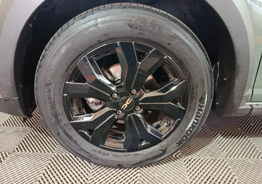 Gros plan sur la roue avant droite de la Dacia Sandero Extreme+ 2024 avec jante noire brillante et pneu Hankook.