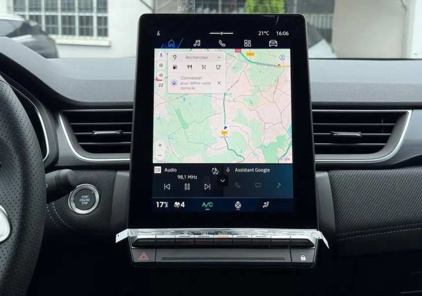 Vue intérieure centrée sur l'écran tactile vertical du tableau de bord du Renault Symbioz gris Rafale avec commandes climatisation.