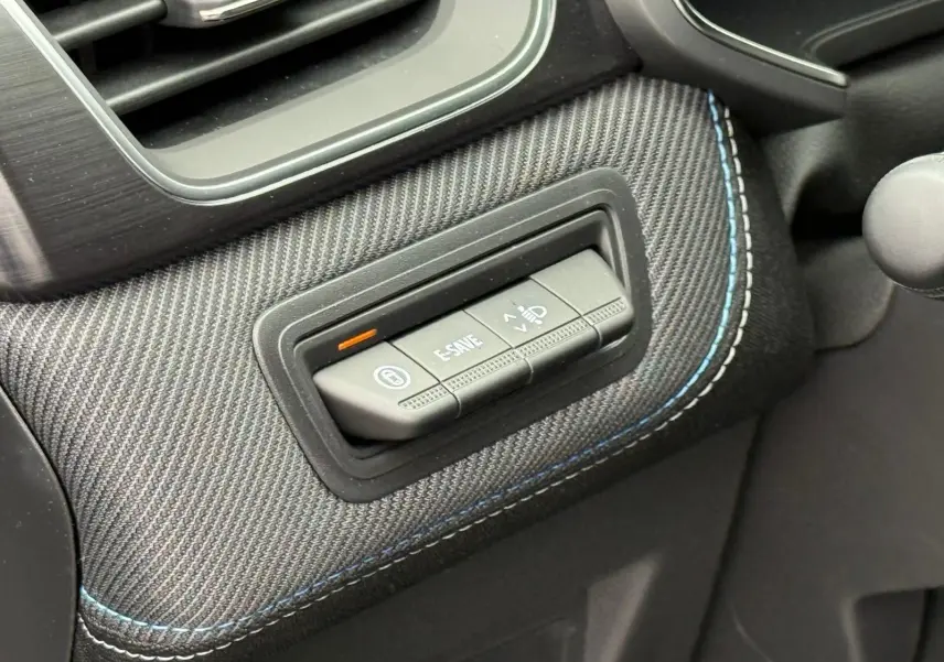 Détail intérieur montrant les boutons de commande sur une garniture en tissu gris avec surpiqûres bleues du Renault Symbioz 2026.