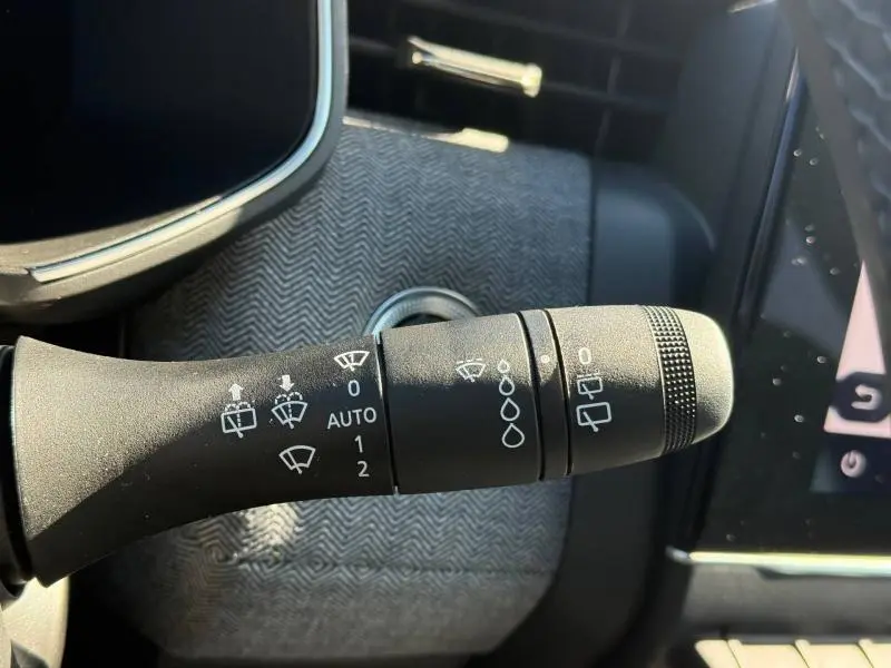 Gros plan sur la commande des essuie-glaces dans l’habitacle d’une Renault Clio 1.0 TCe 90ch Techno 2025, intérieur gris.