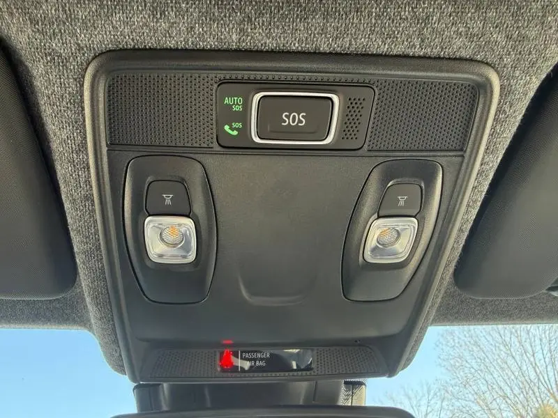 Vue en contre-plongée du plafonnier intérieur noir de la Renault Clio 2025 avec bouton SOS et éclairages intégrés.