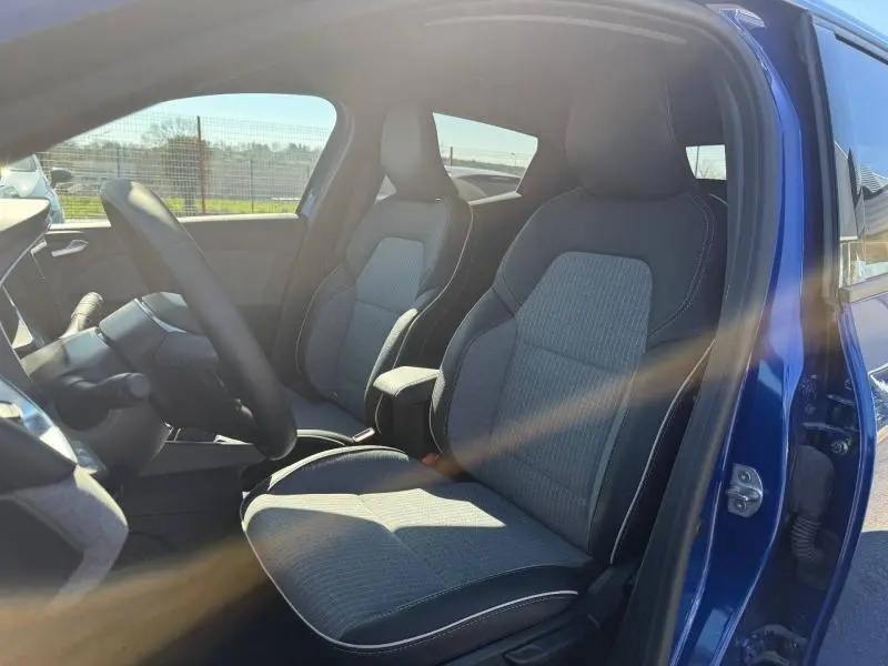 Vue intérieure côté conducteur de la Renault Clio 1.0 TCe 90ch Techno 2025 en Bleu Iron, sièges tissu et cuir contrasté.