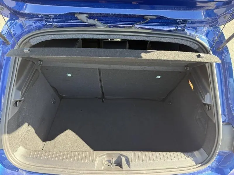 Coffre ouvert vu de dessus d'une Renault Clio 2025 Bleu Iron, montrant l'espace de chargement vide et la tablette arrière.